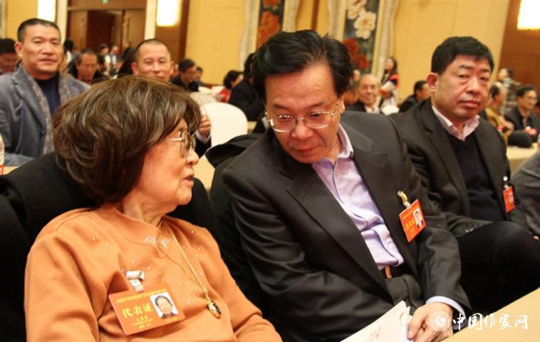 文潔若、李福明等代表在報告會前交談。