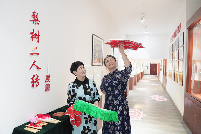2023年6月29日，在吉林省梨樹(shù)縣地方戲曲劇團(tuán)梨樹(shù)二人轉(zhuǎn)展廊，團(tuán)長(zhǎng)趙丹丹（右一）為作家龔保華講解二人轉(zhuǎn)技巧。