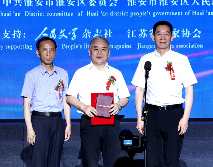 中國(guó)作家協(xié)會(huì)黨組成員、書記處書記、《人民文學(xué)》雜志社主編施戰(zhàn)軍，淮安市人大常委會(huì)副主任范更生為王躍文頒獎(jiǎng)