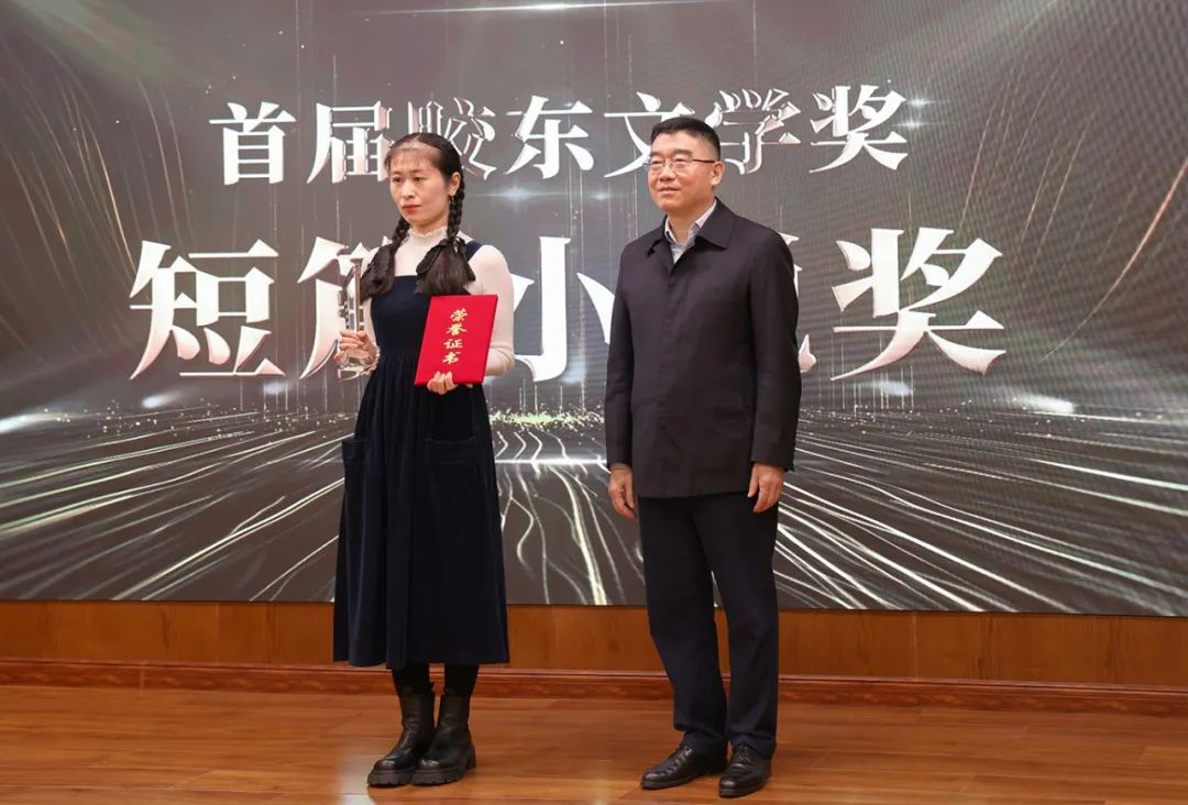 山東省作協(xié)黨組書記、副主席趙藝?。ㄓ乙唬? 為短篇小說獎(jiǎng)獲得者王銘嬋頒獎(jiǎng)
