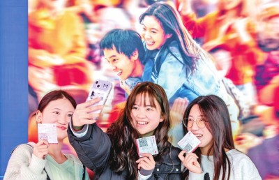 2月18日，觀眾在貴州省黔西市一家影院的電影海報前留影。 新華社發(fā)