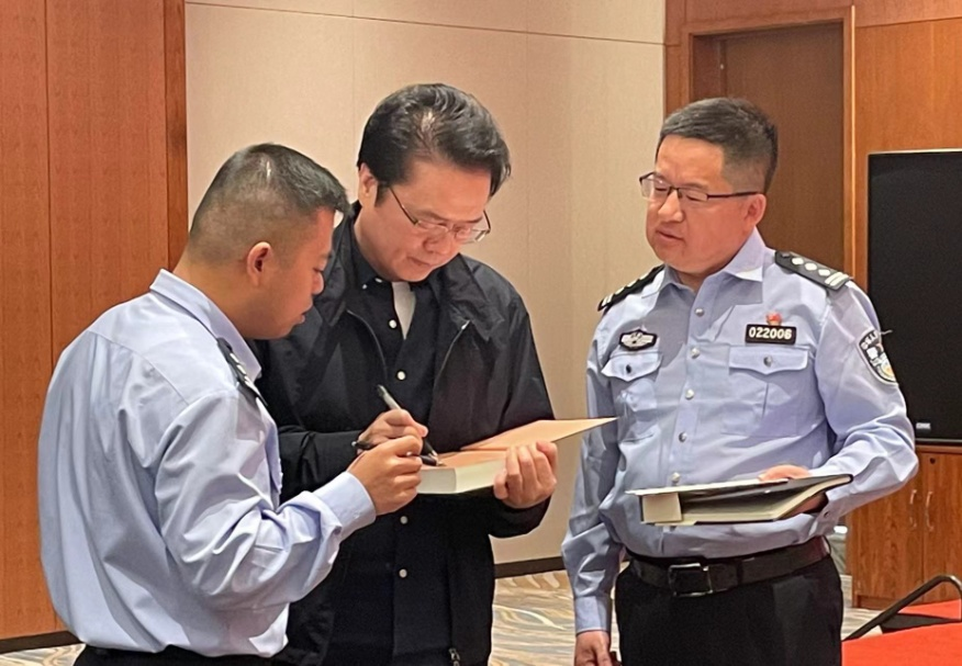 活動期間，陳彥（圖中）在給警營作家簽名。