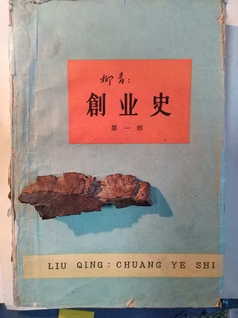 長篇小說《創(chuàng)業(yè)史》（第一部）書影與柳青曾收藏的彈片。 （文金 攝）