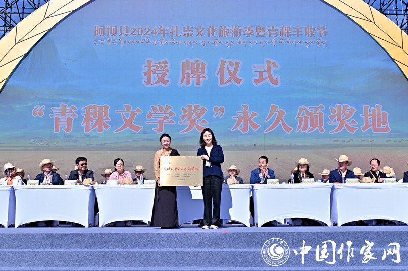陳亞軍主編代表《民族文學》向阿壩縣授牌，紅梅部長接牌。