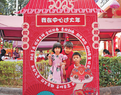 老撾民眾在“歡樂(lè)春節(jié)”廟會(huì)現(xiàn)場(chǎng)設(shè)立的新春祈福打卡點(diǎn)拍照。  坎帕頌攝