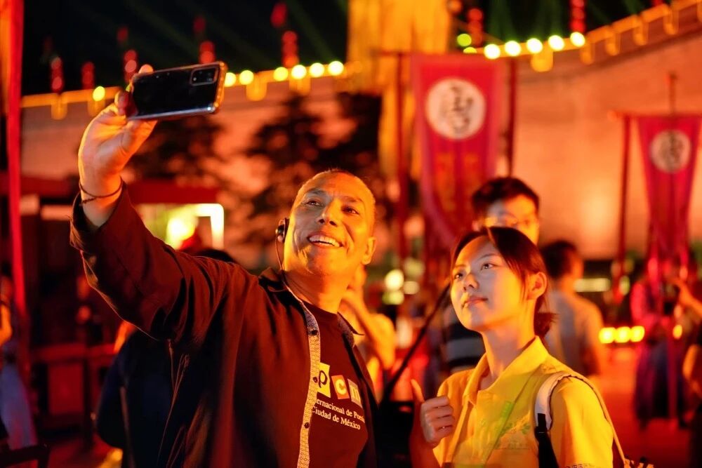 參加2025國際青春詩會的拉美詩人和中國詩人在西安永寧門觀看歡迎儀式。圖為墨西哥詩人馬努艾爾·夸烏特勒在歡迎儀式后與志愿者合影